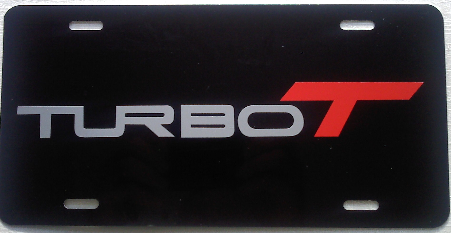 Turbo T Stamped license plate, black with silver and red lettering